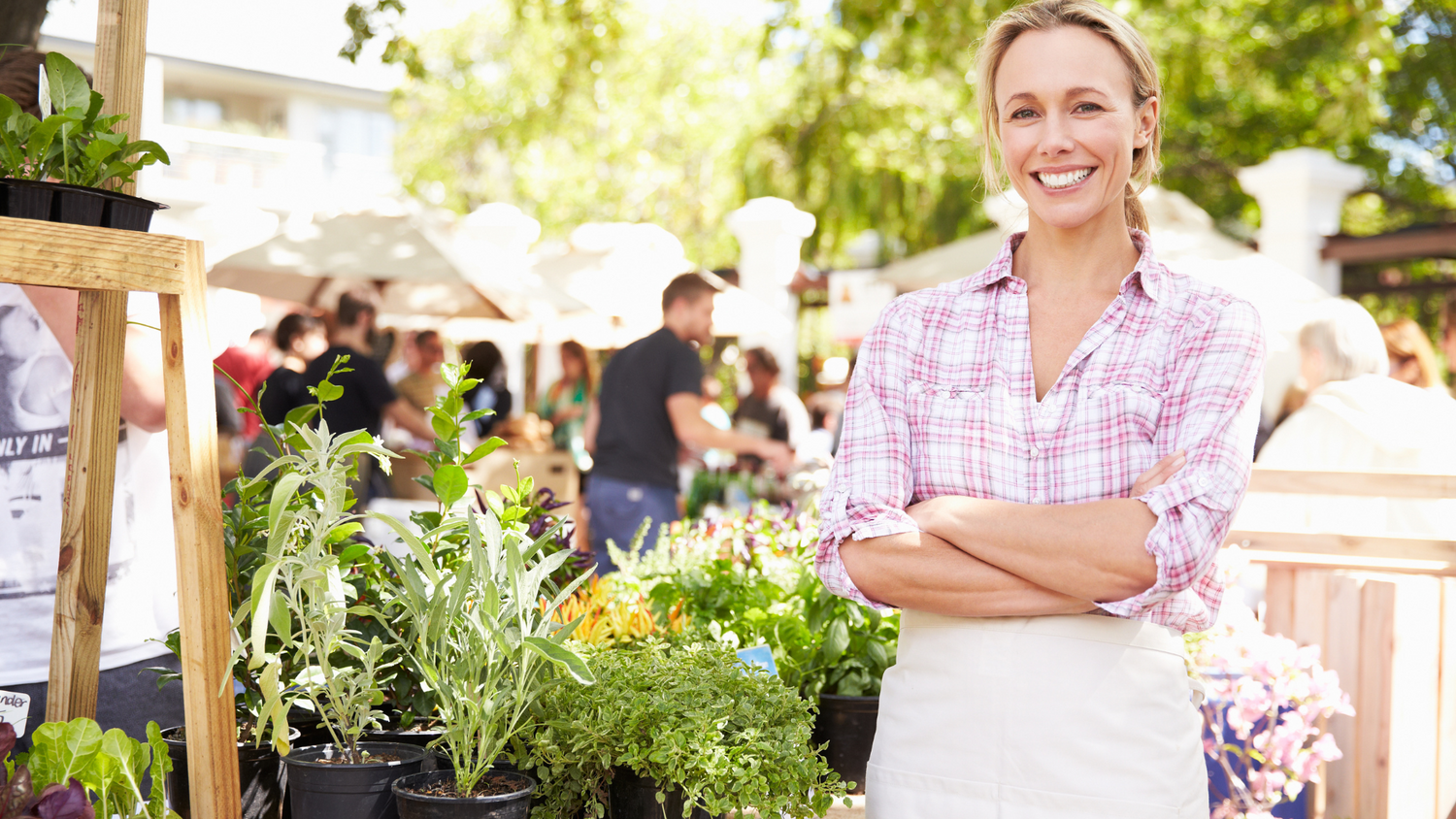 women standing at a market stall of plants